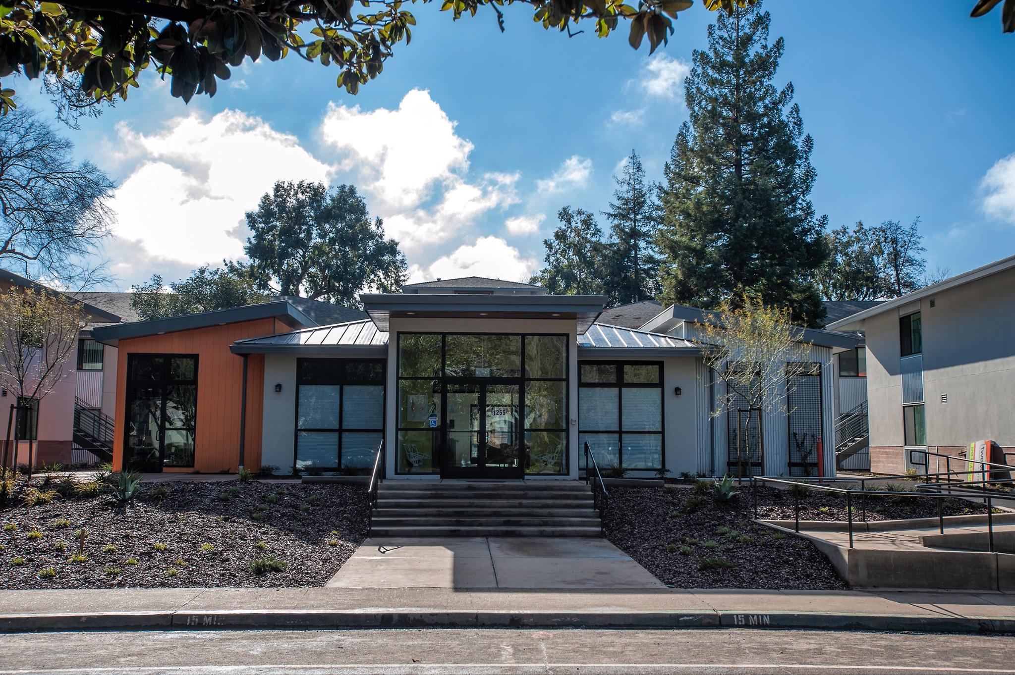 Apartment community leasing office exterior with glass entry and updated facade